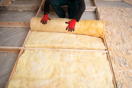 Hands installing insulation